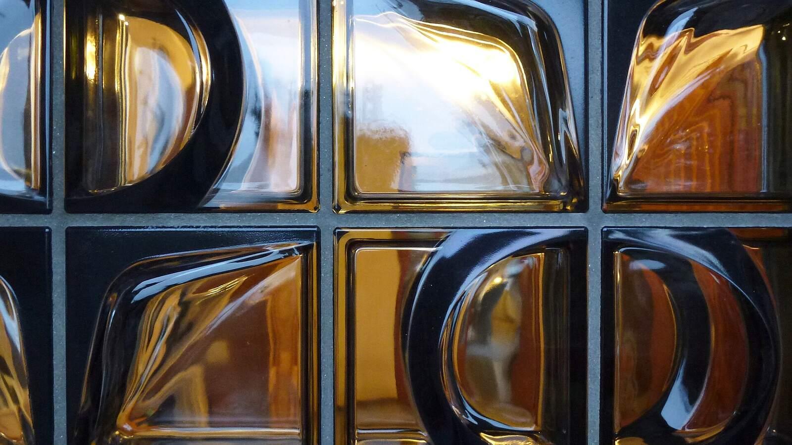 Gros plan sur des pavés de verre ondulés montés dans un mur, en Suède