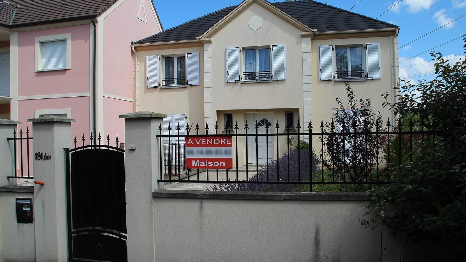 Maison individuelle avec un panneau « À vendre » accroché à la grille, aux Ulis