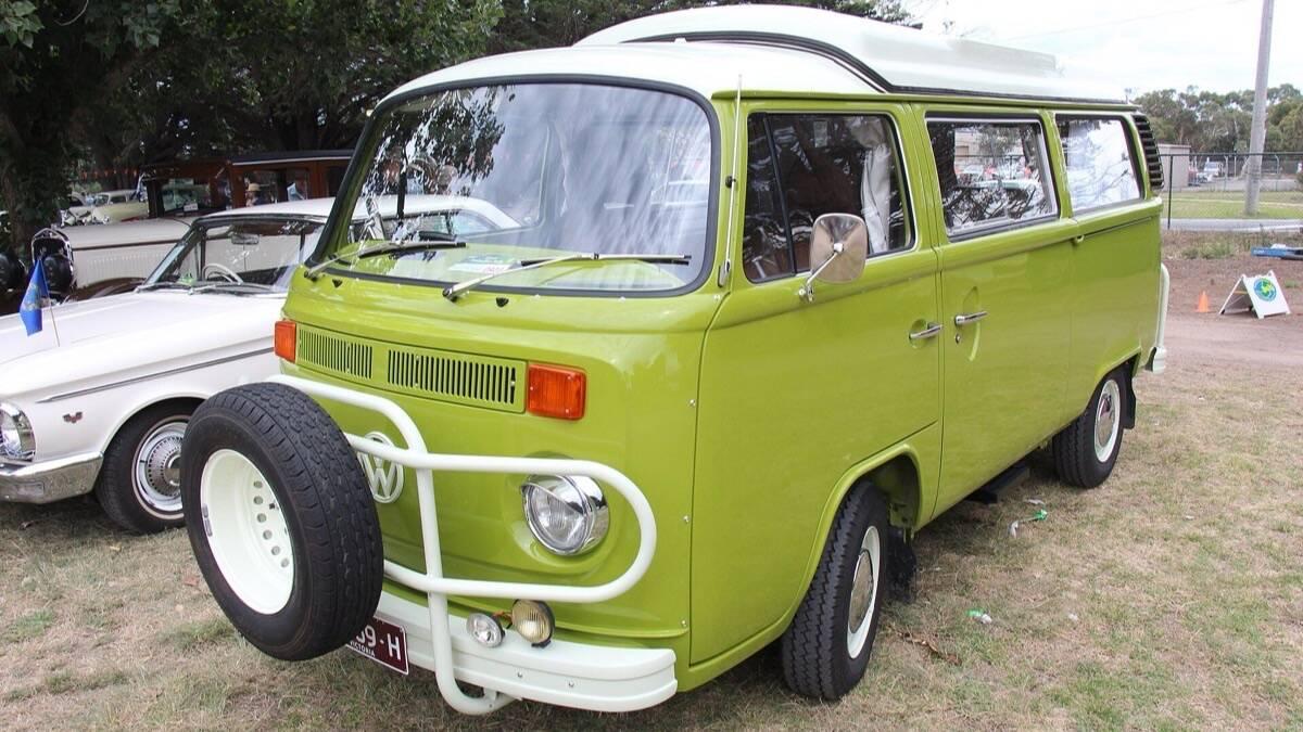 Combi Volkswagen vert des années 1970 aménagé en camping-car, garé sur l'herbe